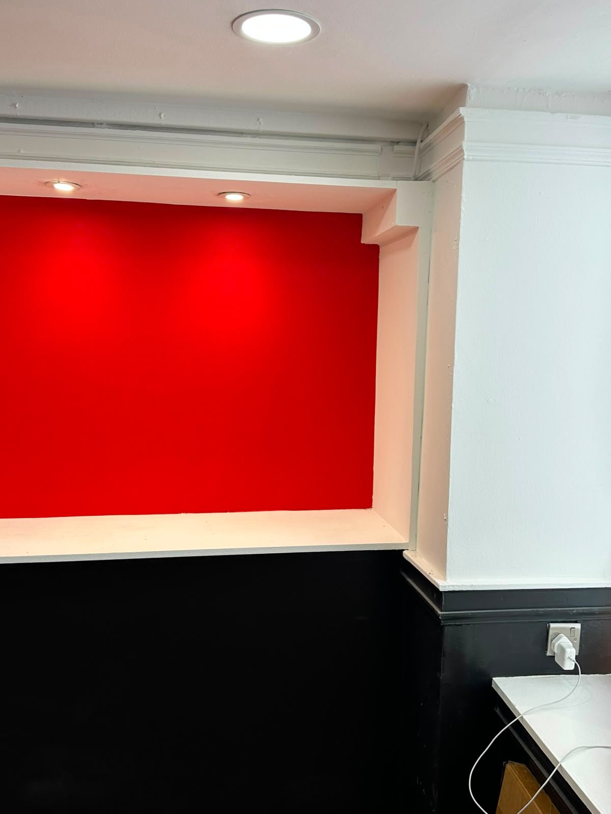 Bold red accent wall with recessed lighting
